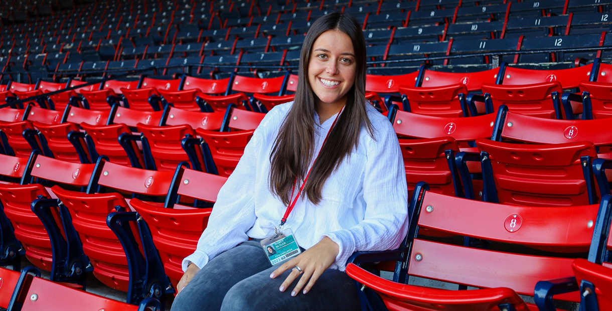 Woman sitting in the red stands at Fenway park
