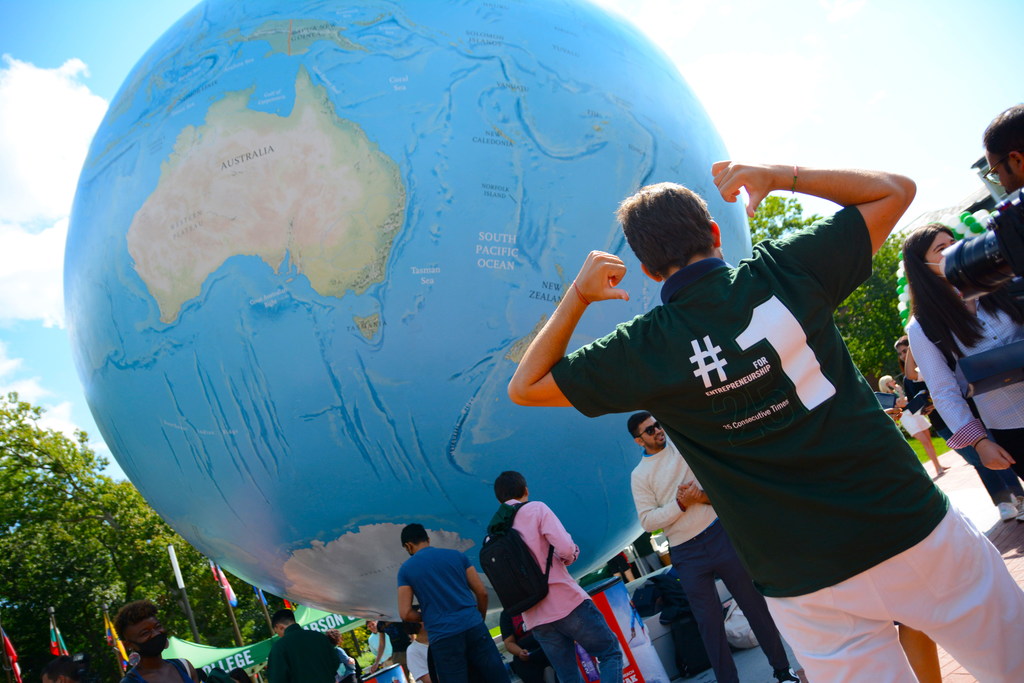 Student wearing #1 shirt in front of globe