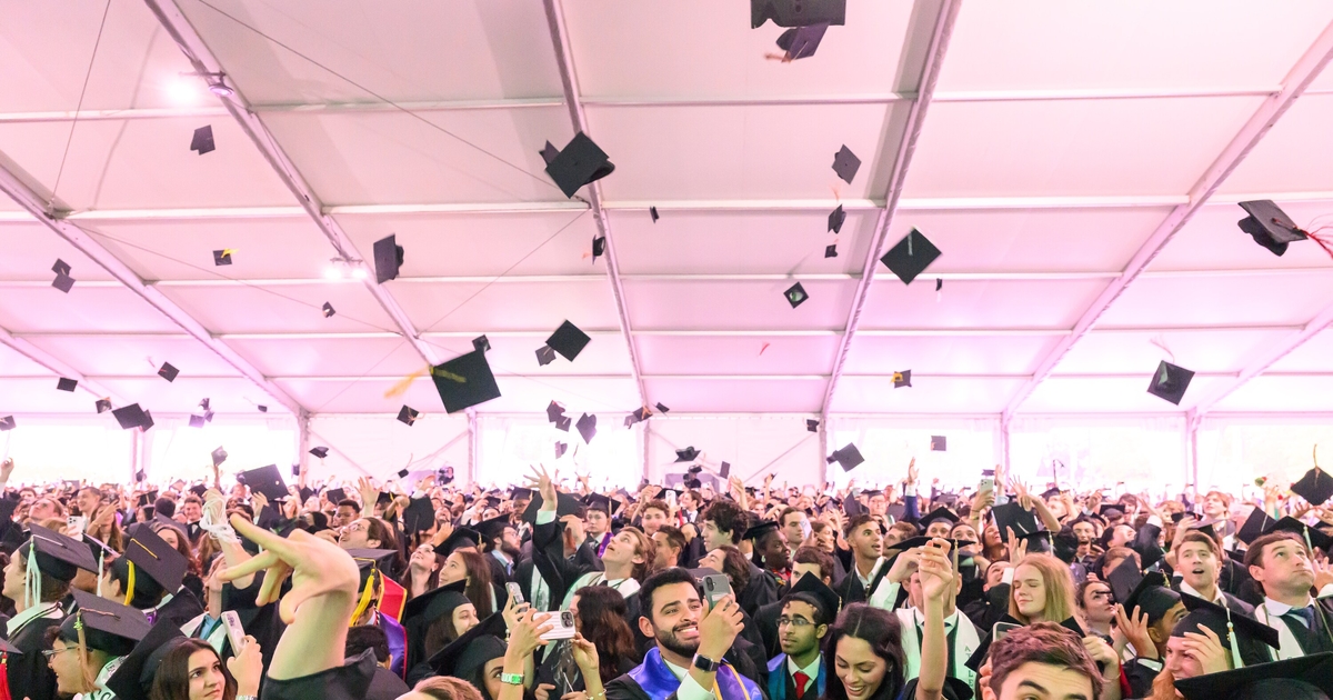 Students throwing their graduation caps in the air at commencement