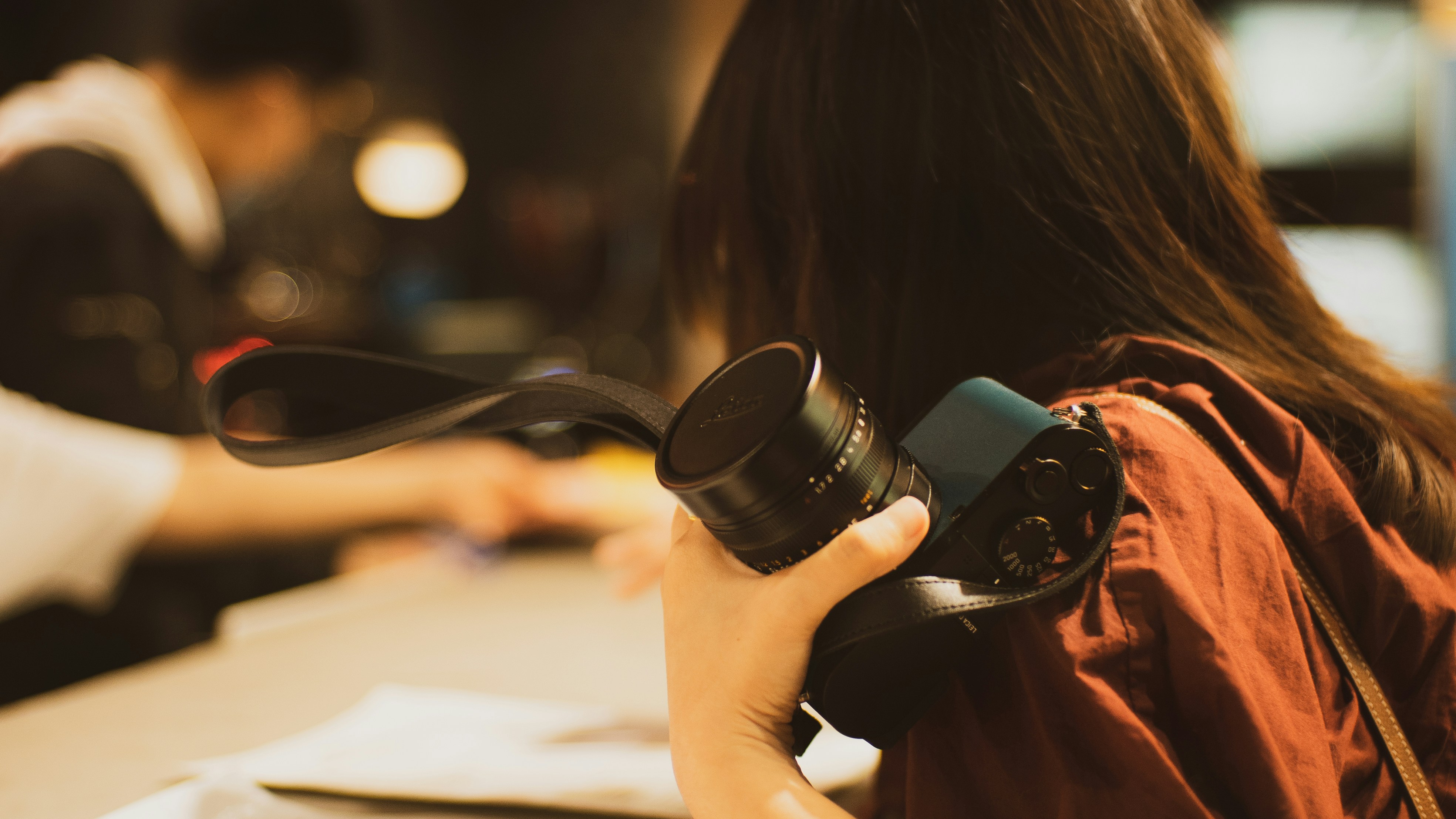A person holding a camera while looking at a notebook