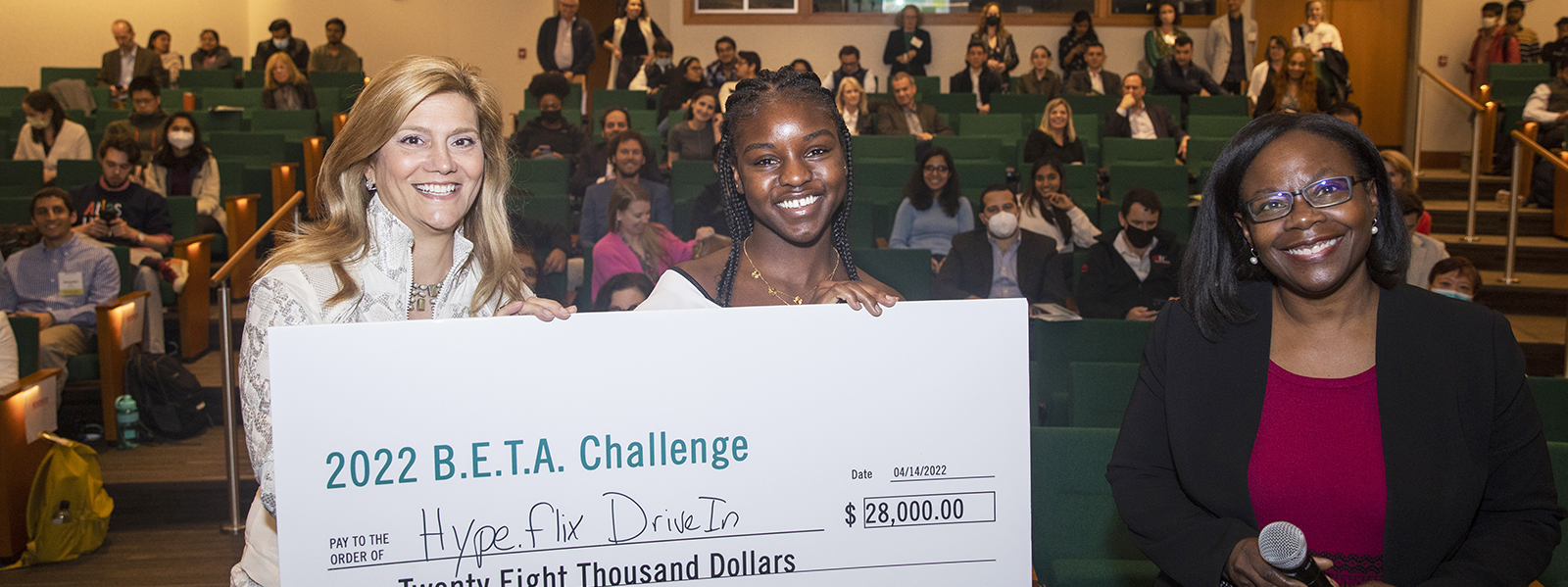 Three women holding a check