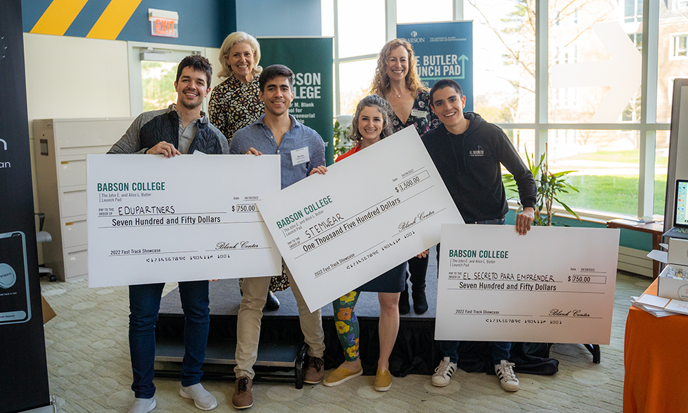 Students holding checks on stage