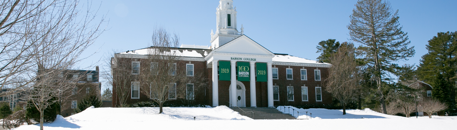 Centennial banner Tomasso Tomasso building with snow