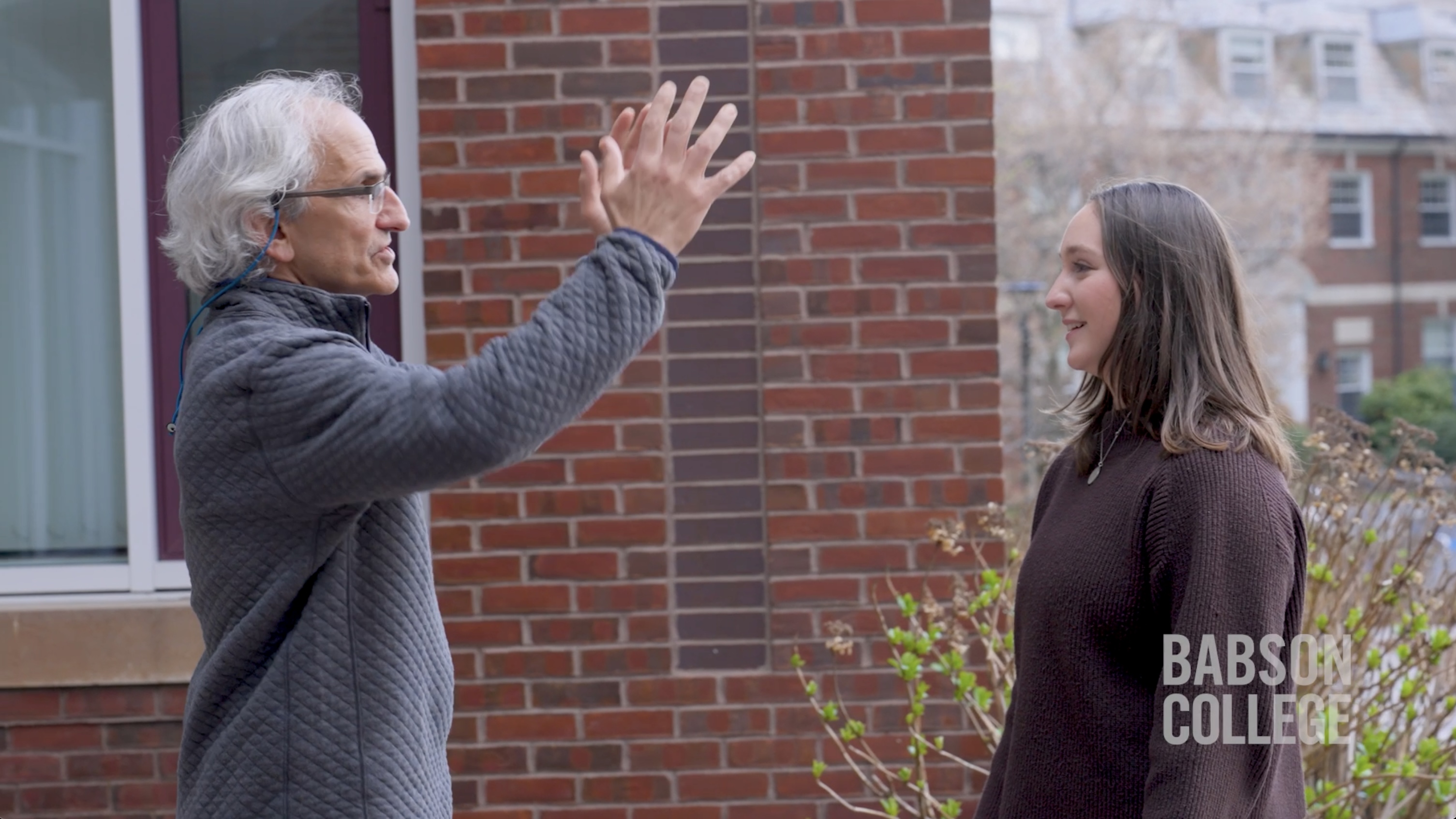 faculty and student animatedly talking to each other
