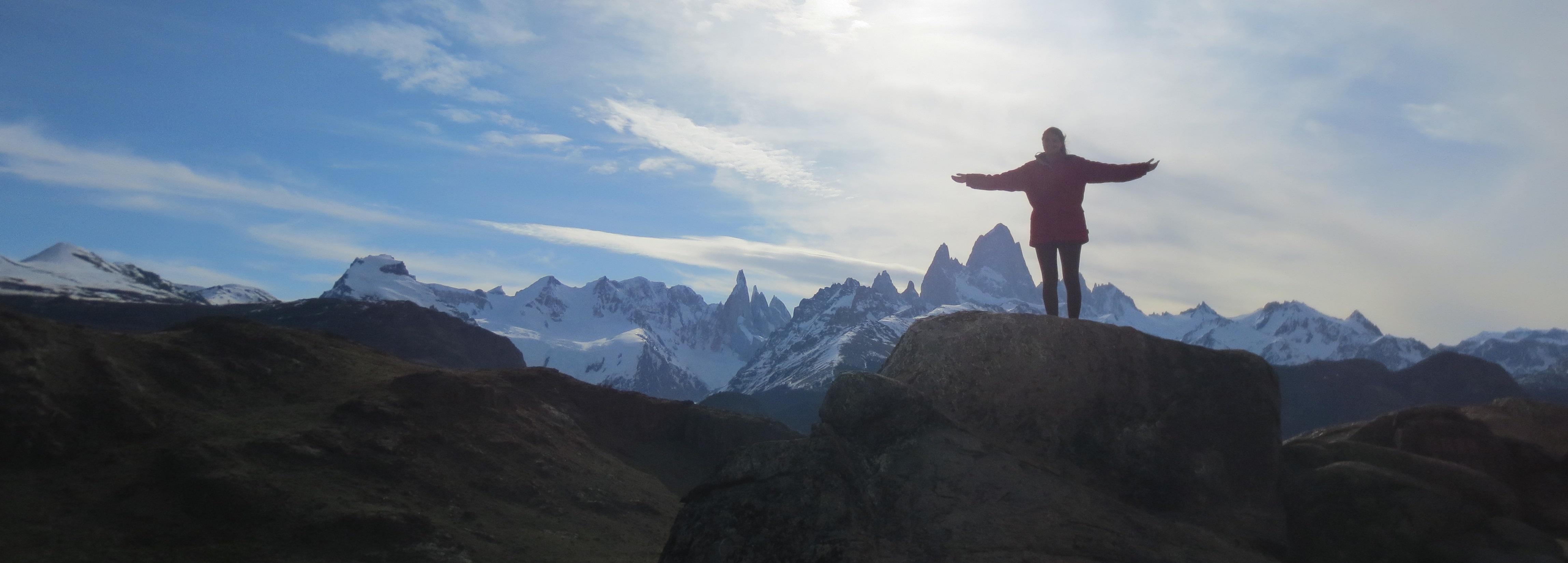 Student standing in front of mountains covered in shadow. Photo courtesy of Catherine Vedovino.