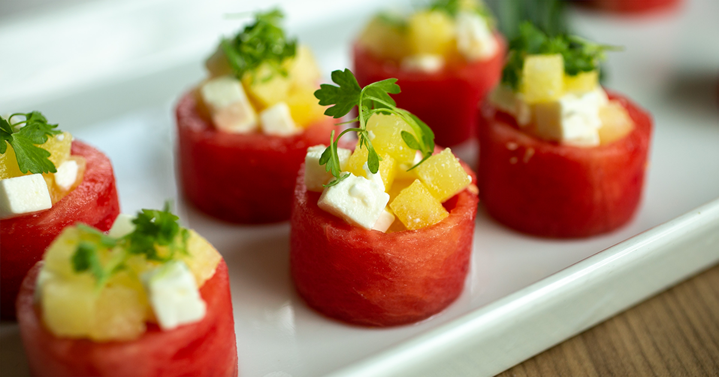 photo of a watermelon cups topped with feta and mango.