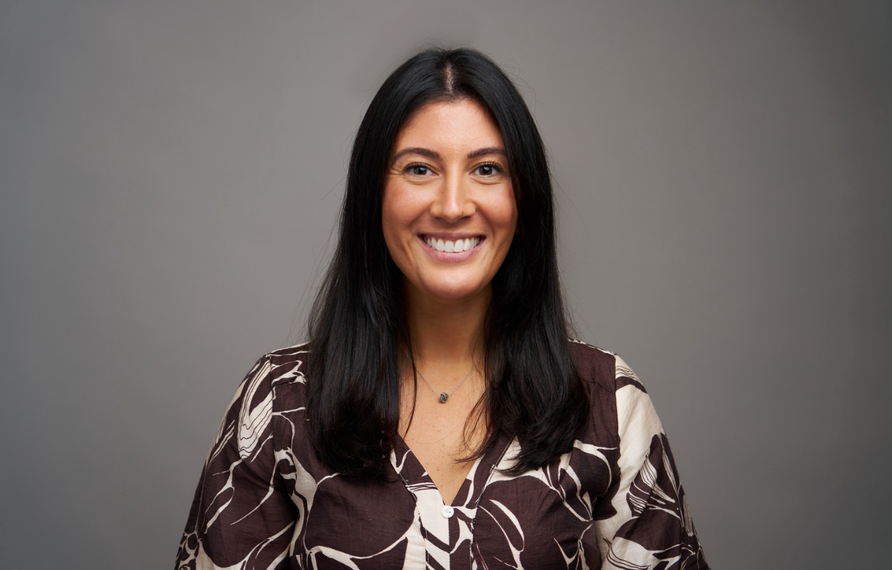 Headshot of a woman in a brown and white dress