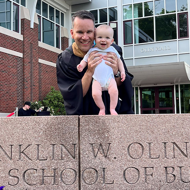 father and baby in front of Olin grad school