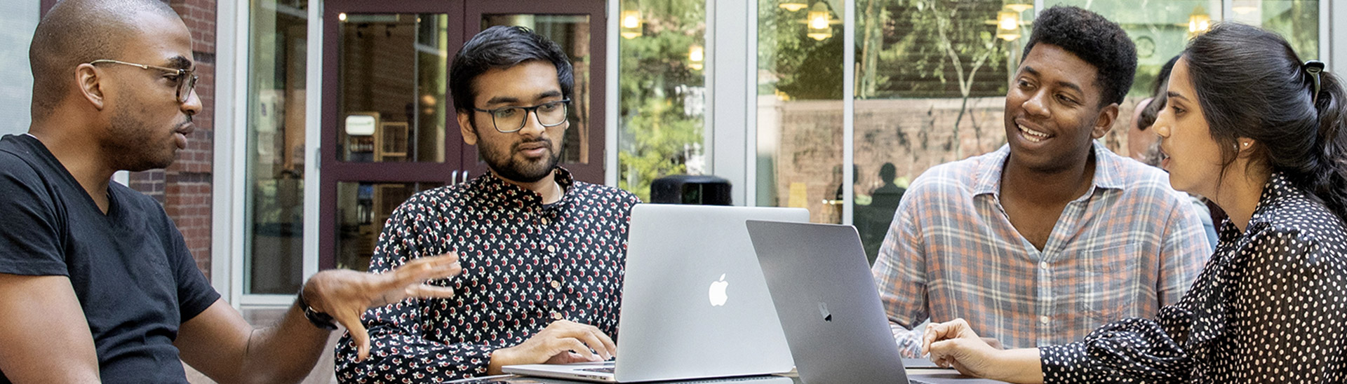 Students on laptops in conversation