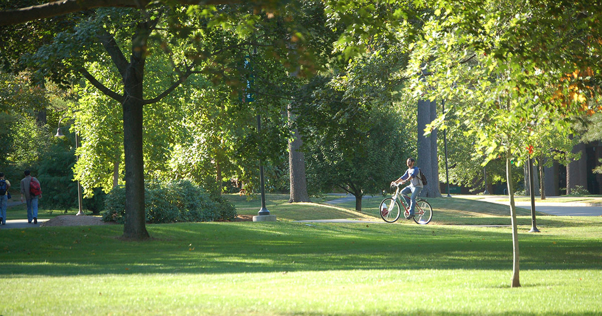 student on a bike through campus