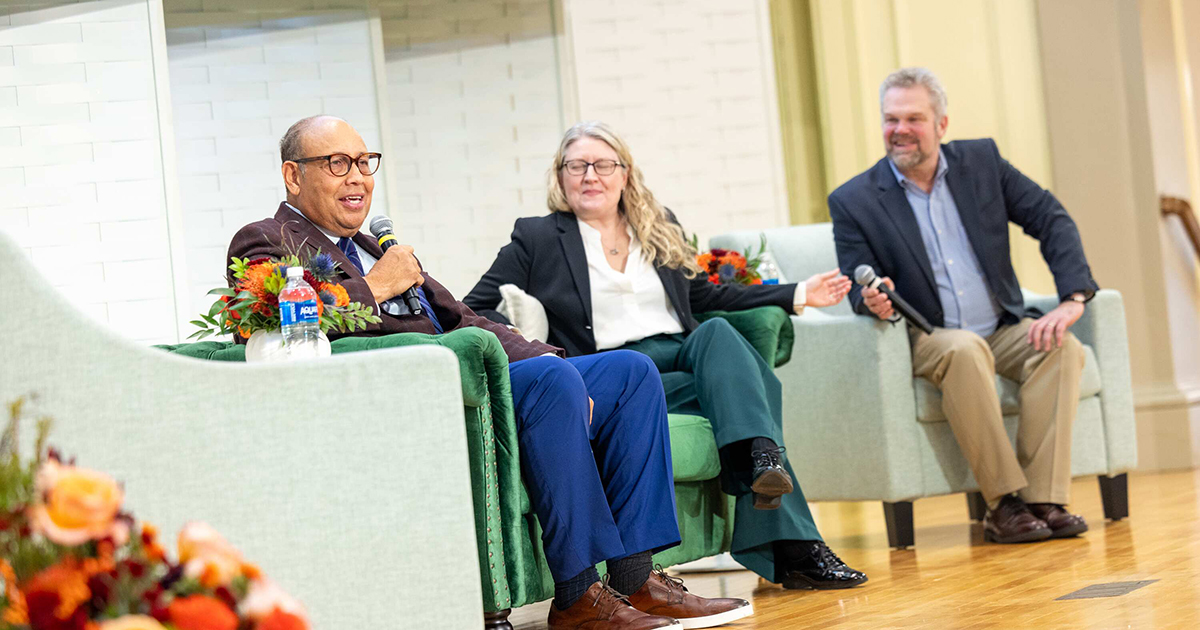 Three people talking on a panel