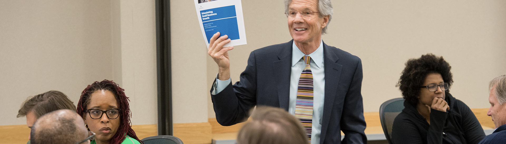 Person holding print material in front of a group