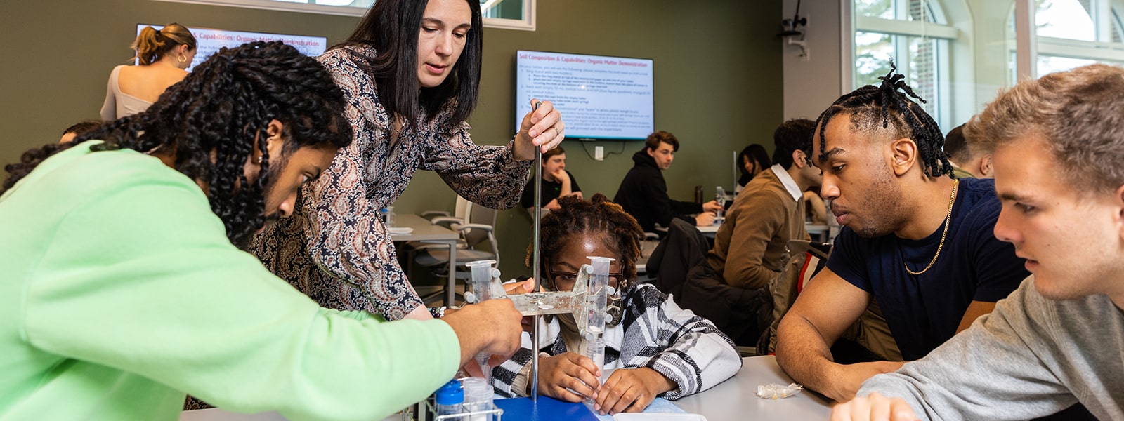 A teacher in a science class with four students