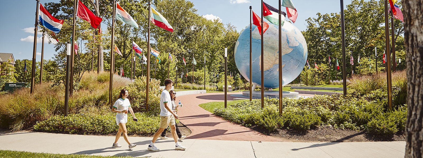 Three students walking in front of the Globe